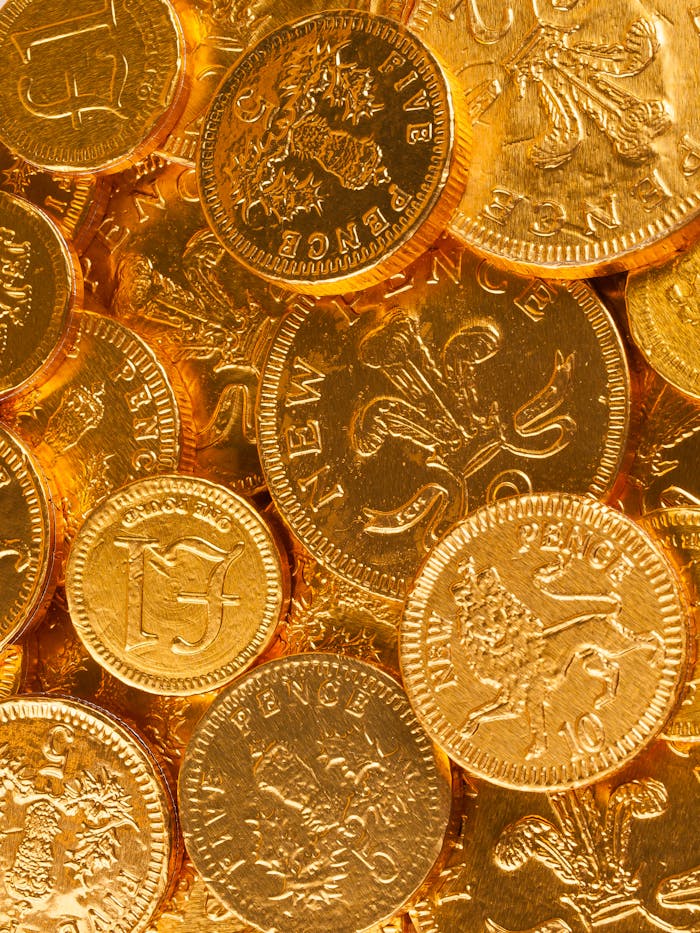 A collection of British gold coins displaying intricate emblems, symbolizing wealth and history.