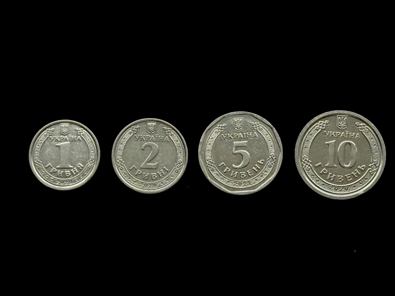 Close-up of Ukrainian hryvnia coins displayed on a black background.